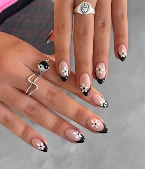 Orange blue flower nail designs - colorful hand showcasing orange and blue flower petals, featuring green leaves and stems on almond-shaped nails